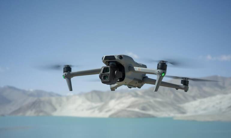 DJI Air 3S camera drone flying above a mountain lake